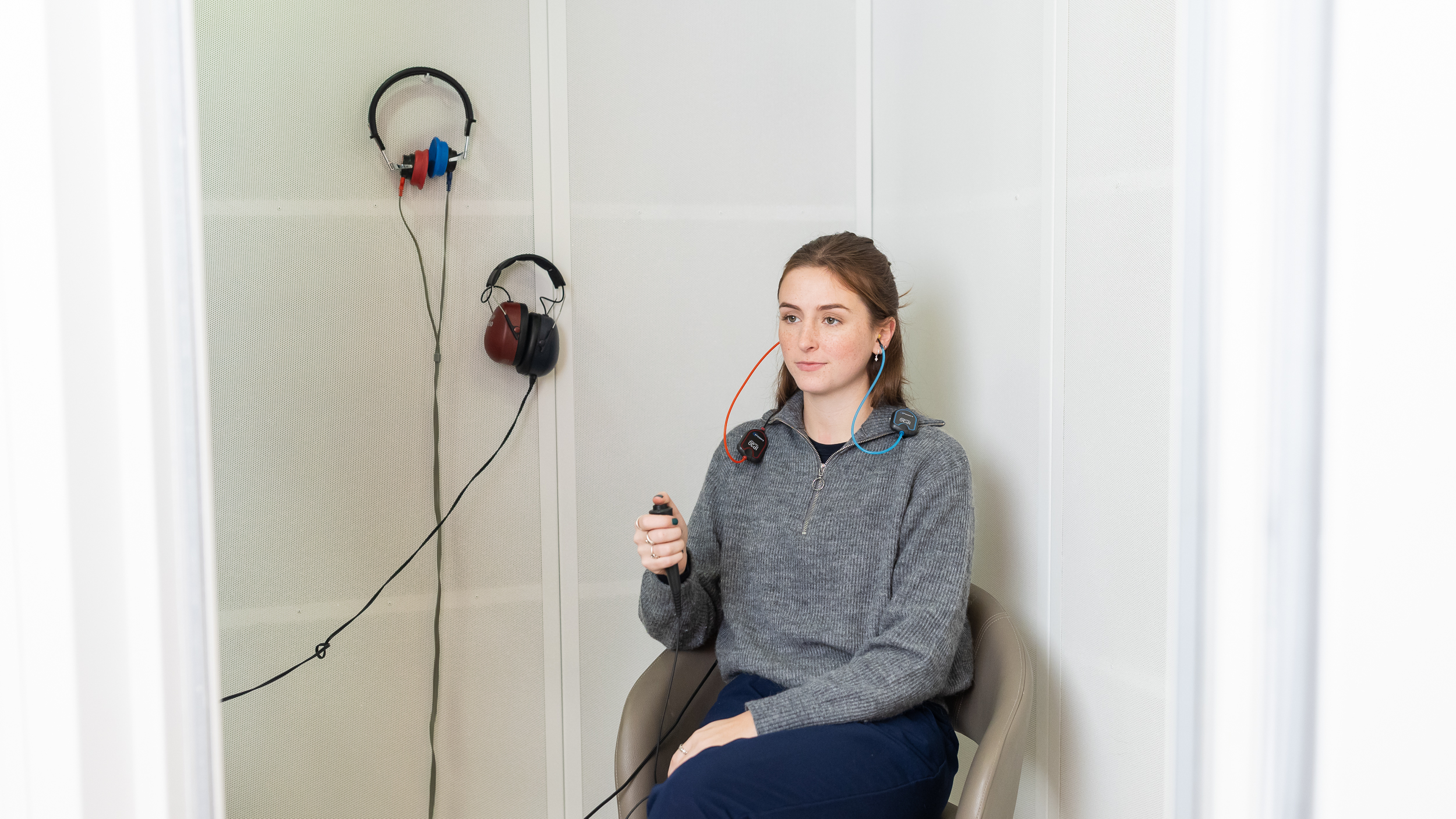 Patient completing a hearing test inside a sound booth